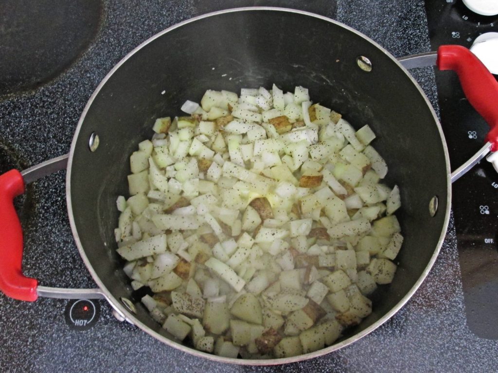 Cooking Onion and Potato base in a large pot to make chicken corn chowder.