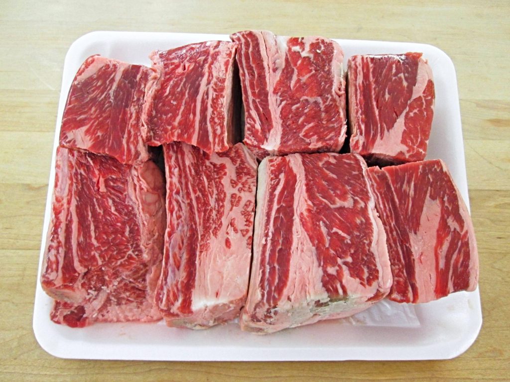 8 raw beef short ribs removed from their plastic packaging.